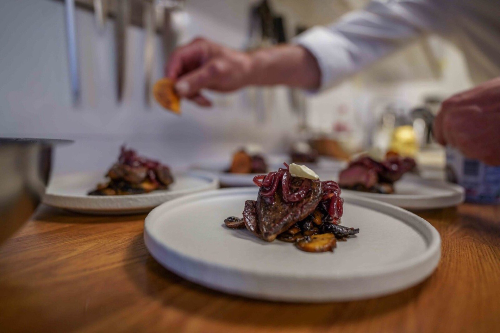 A plated main course being finished